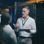IT technicians removing servers and networking equipment during a secure data center decommissioning project for certified IT Asset Disposition and electronics recycling.